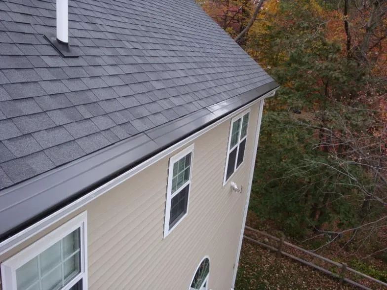 Gutter Cap installed along the roof edge of a tan house seen from above