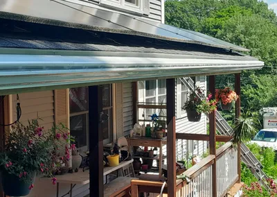 Gutter Cap over a porch roof with hanging flower baskets below