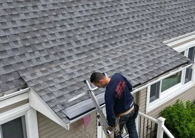 Installer securing Gutter Cap along a shingled roofline