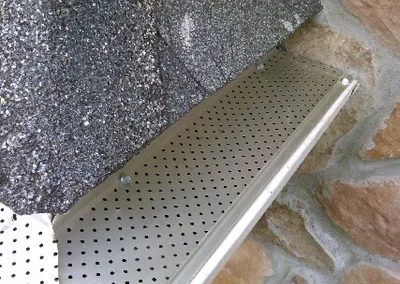 Close-up of the perforated gutter screen at the roof edge