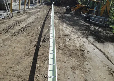 Long seamless gutter run laid out on the ground before hanging