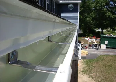 Underside view of a seamless gutter run showing the hanger brackets