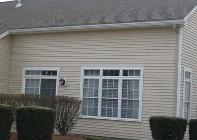 New gutters on the gable end of a cream-colored house